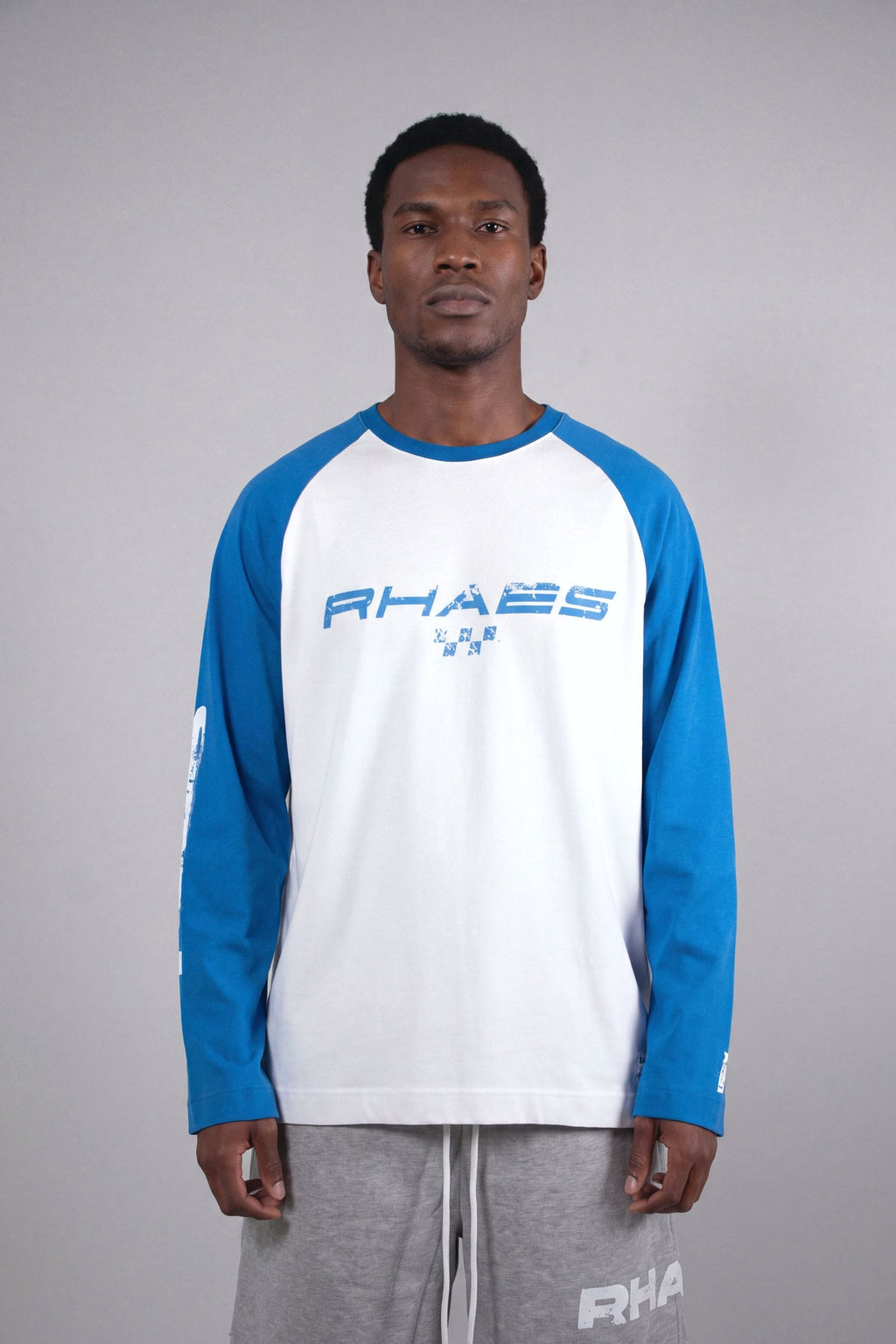Model wearing RHAES 1995 Raglan Long Sleeve — distressed RHAES chest print