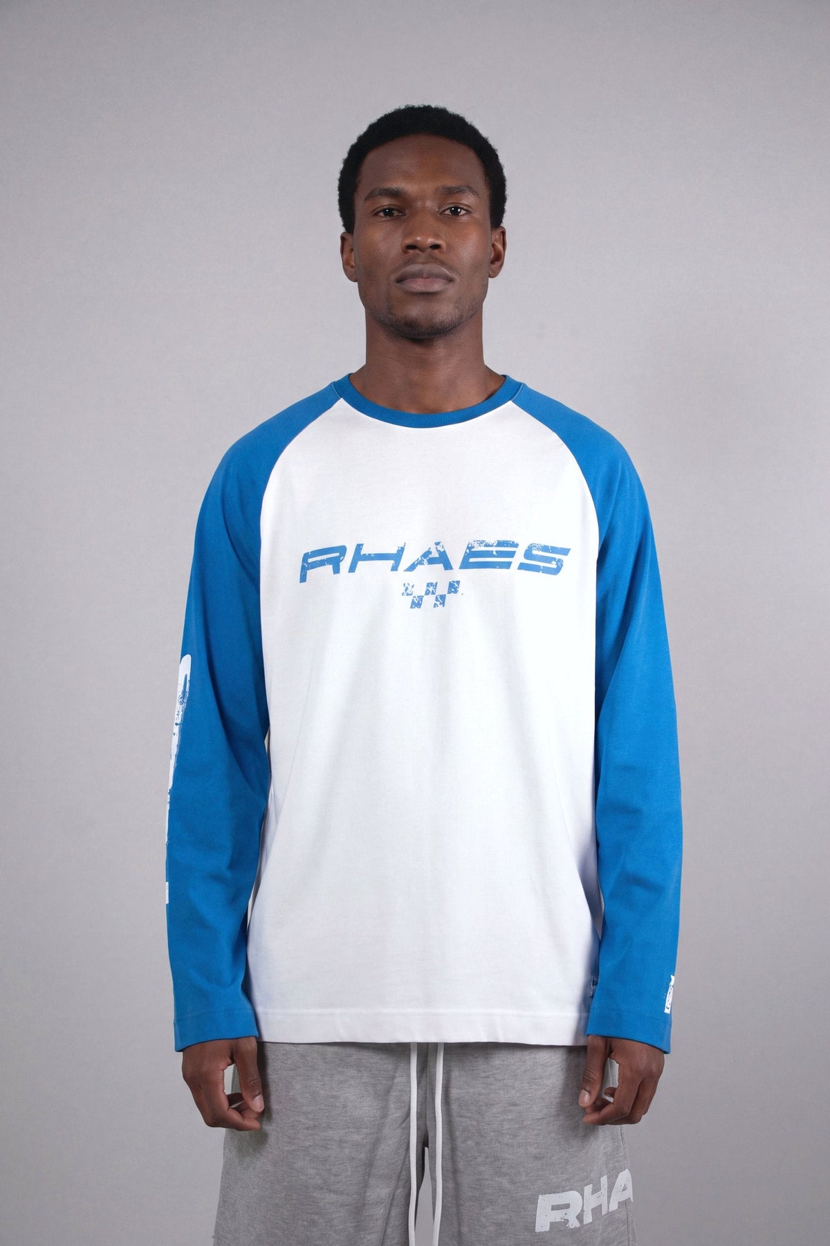 Model wearing RHAES 1995 Raglan Long Sleeve — distressed RHAES chest print