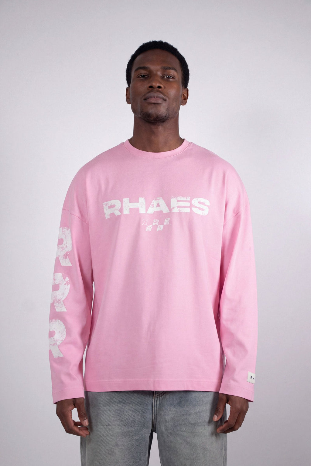 Model wearing RHAES 22 Long Sleeve in Soft Pink — distressed RHAES chest print